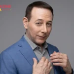 Paul Reubens, actor and comedian who created Pee-wee Herman, wearing a blue blazer in a professional portrait