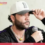 Darey Castro holding a microphone in a black hoodie and white cap, with a DP neck tattoo visible