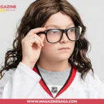 A young child wearing an NHL hockey jersey and glasses, adjusting their frames in a casual photo.
