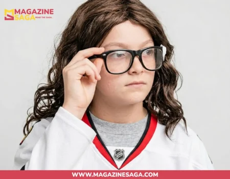 A young child wearing an NHL hockey jersey and glasses, adjusting their frames in a casual photo.