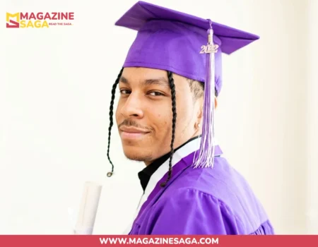 Isaiah Rahsaan Iverson in purple graduation cap and gown holding a diploma at his 2022 high school graduation