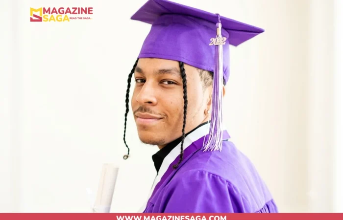 Isaiah Rahsaan Iverson in purple graduation cap and gown holding a diploma at his 2022 high school graduation