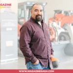 Juan Ibarra holding a welding helmet in front of heavy equipment at an industrial facility