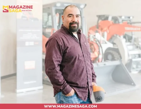 Juan Ibarra holding a welding helmet in front of heavy equipment at an industrial facility