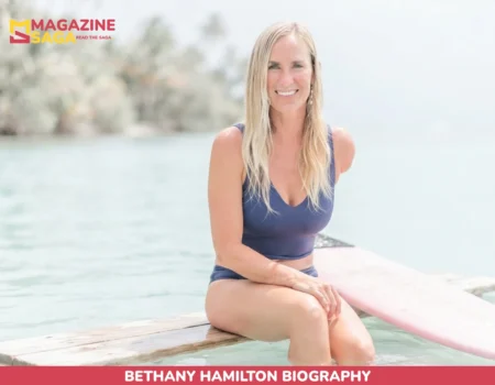 Bethany Hamilton, a surfer with one arm, sitting on a wooden dock beside a pink surfboard
