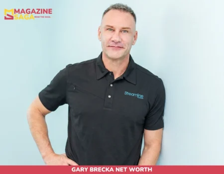 Gary Brecka net worth subject smiling in black Streamline polo against light blue wall