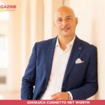 Gianluca Cugnetto net worth photo, hotelier in navy blazer standing in a sunlit hallway