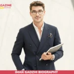 Iman Gadzhi biography portrait in navy suit holding notebook