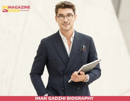 Iman Gadzhi biography portrait in navy suit holding notebook