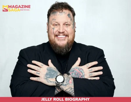 Jelly Roll biography photo, smiling man with face and hand tattoos in black suit