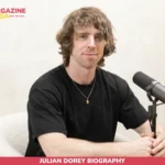 Julian Dorey biography photo, seated at studio microphone in black t-shirt