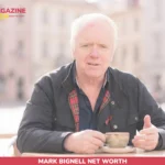 Mark Bignell Net Worth – Inside His 2025 RTÉ Comedy Role Mark Bignell sits at an outdoor café table holding a coffee cup for net worth article