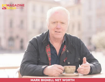 Mark Bignell sits at an outdoor café table holding a coffee cup for net worth article
