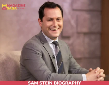 Sam Stein smiling in gray suit and striped tie during TV studio interview