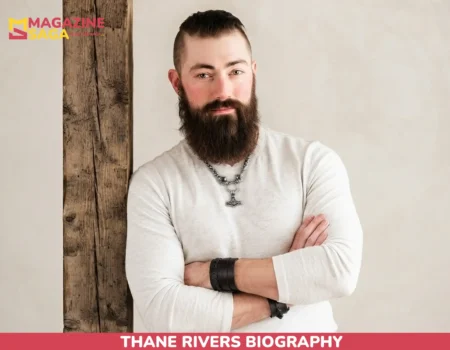 Thane Rivers biography portrait, bearded man in cream sweater with pendant necklace