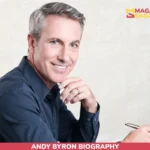 Andy Byron seated in navy shirt with pen and notebook for net worth article