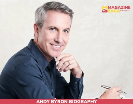 Andy Byron seated in navy shirt with pen and notebook for net worth article
