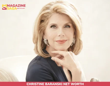Christine Baranski net worth portrait, seated in a navy blazer with diamond earrings
