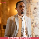 Omar Fateh net worth in a gray suit standing by marble columns for the article