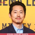 Steven Yeun close-up portrait in a navy blazer for the Steven Yeun net worth article