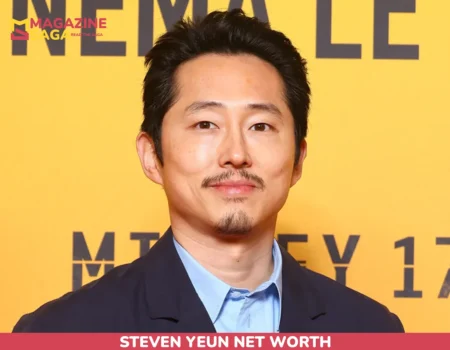 Steven Yeun close-up portrait in a navy blazer for the Steven Yeun net worth article