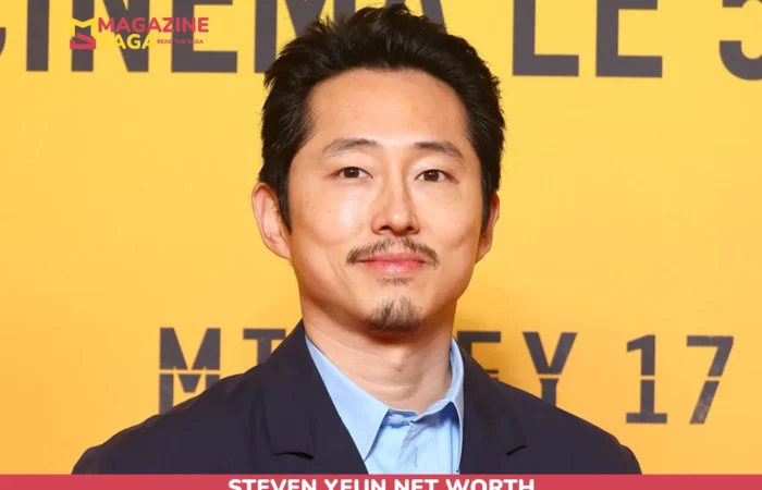 Steven Yeun close-up portrait in a navy blazer for the Steven Yeun net worth article