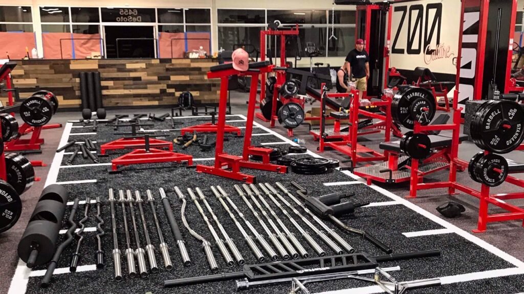 Zoo Culture gym interior with red equipment racks and barbells, tied to the Bradley Martyn net worth article