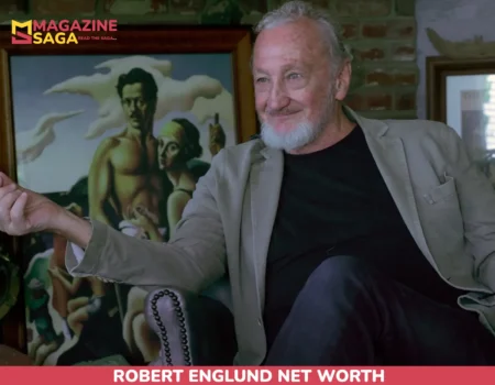 Robert Englund net worth gesturing during a interview, seated beside a vintage diving helmet