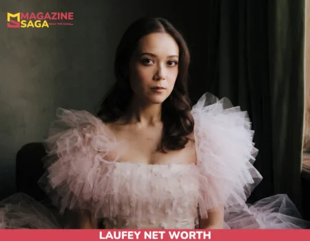Laufey seated by a window in a pink ruffled tulle gown, portrait for the Laufey net worth article