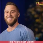Mike Posner, bearded and smiling in a blue t-shirt with a headset microphone, for the Mike Posner net worth article