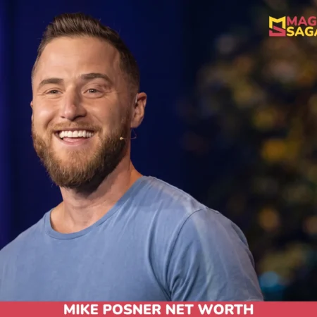 Mike Posner, bearded and smiling in a blue t-shirt with a headset microphone, for the Mike Posner net worth article